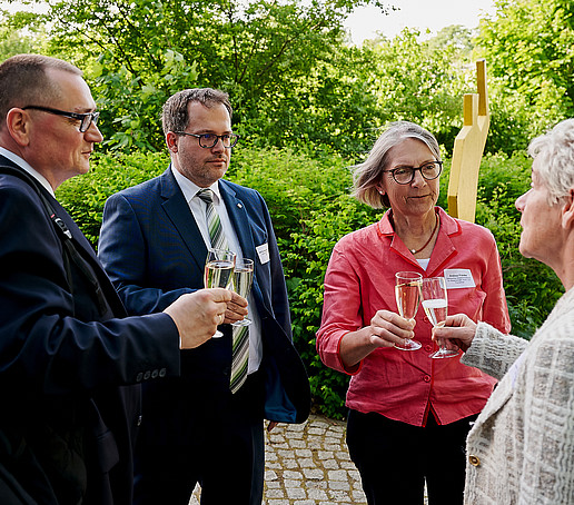 Prof. Knoll, Prof. Kratzsch, Frau Dr. Franke und Frau Martina Weber stoßen gemeinsam mit Sektgläsern im Freien an.