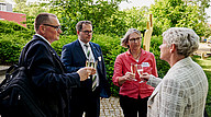 Prof. Knoll, Prof. Kratzsch, Frau Dr. Franke und Frau Martina Weber stoßen gemeinsam mit Sektgläsern im Freien an.