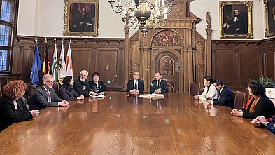 die Delegation der Hochschule und der Mongolei sitzen mit OB Ursu an einem Holztisch im Görlitzer Rathaus.
