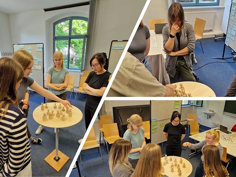 Die Collage zeigt mehrere Szenen aus einem Workshop in einem Seminarraum mit großen Fenstern und Pinnwänden:  Linkes Hauptbild: Fünf junge Frauen stehen um einen kleinen Tisch mit Holzfiguren und diskutieren deren Anordnung. Sie wirken konzentriert.  Rechtes oberes Bild: Eine weitere Gruppe diskutiert ebenfalls über die Positionierung von Holzfiguren. Zwei Teilnehmerinnen stehen nachdenklich, eine mit verschränkten Armen.  Rechtes unteres Bild: Vier Teilnehmerinnen stehen im Kreis um einen Tisch. Eine Frau erklärt etwas mit einer Handbewegung, während die anderen aufmerksam zuhören. Im Hintergrund ist ein Tisch mit Arbeitsmaterialien und eine Moderationswand zu sehen.